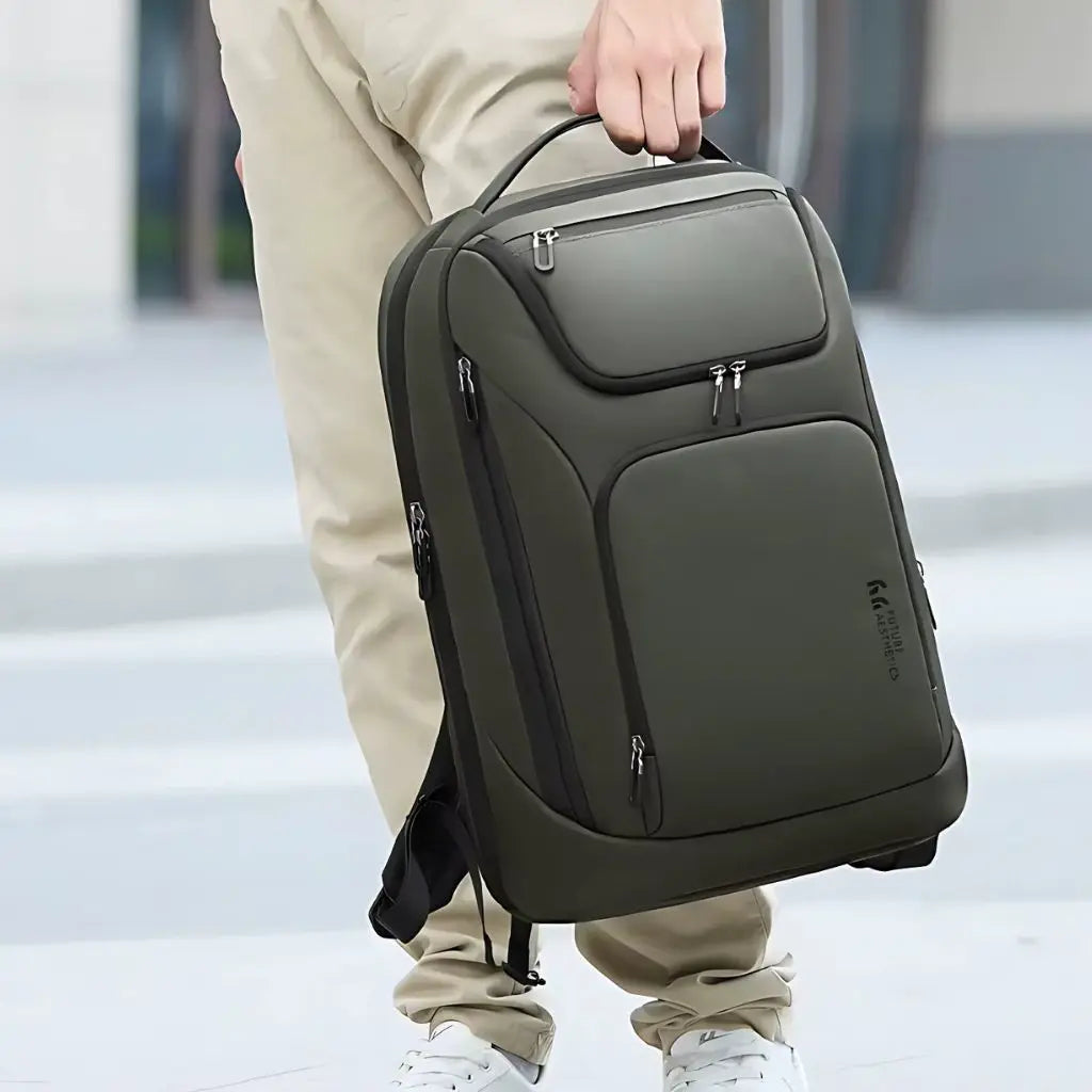 Waterdichte laptop rugzak 16 inch groen met praktisch handvat aan de bovenkant, getoond door een persoon met beige broek, perfect voor openbaar vervoer in Nederland.