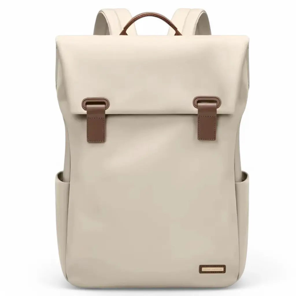 Een elegante beige waterdichte laptop rugzak dames 15.6 inch met minimalistisch ontwerp, bruine leren gespen en draaggreep, zijvakken voor extra opbergruimte en een gouden merklogo onderaan, perfect voor dagelijks professioneel gebruik.