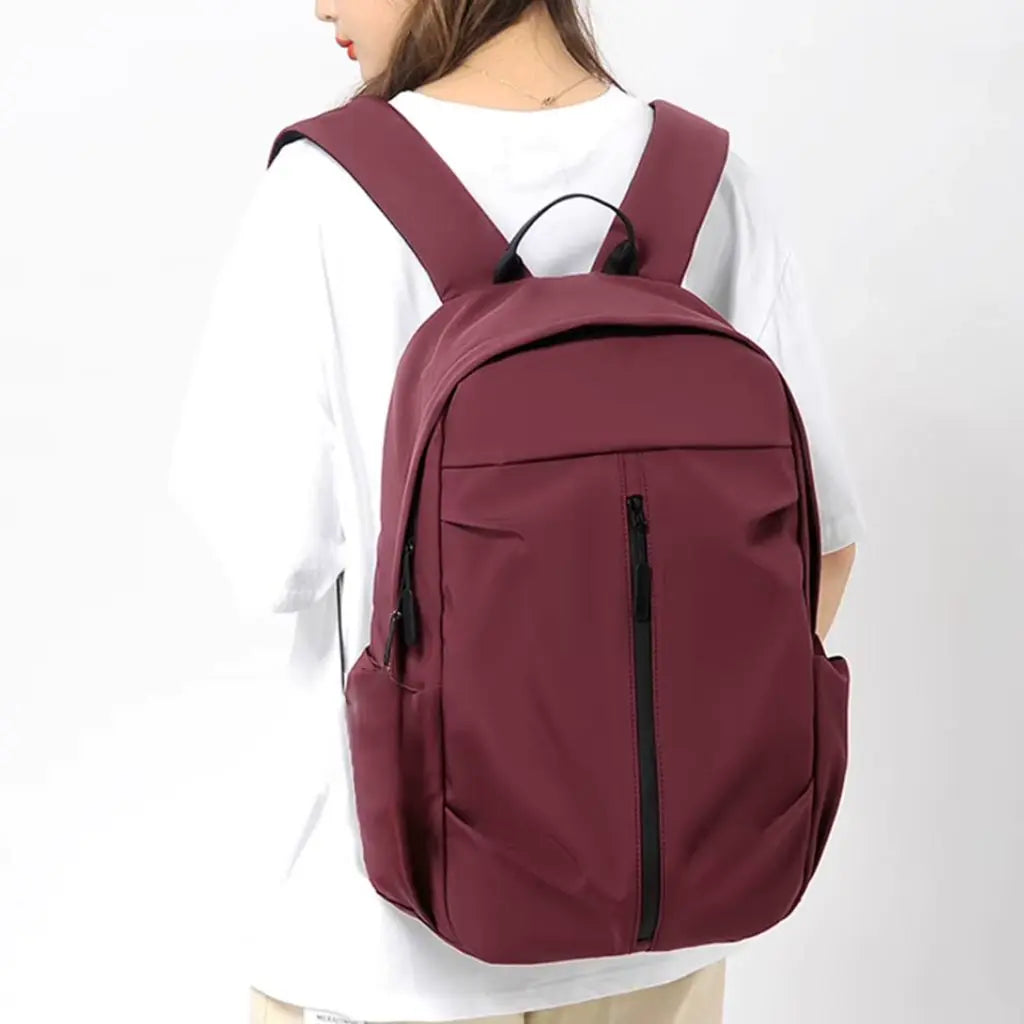Vrouw draagt een rode werk rugzak van 14 inch, met brede schouderbanden voor optimaal draagcomfort.