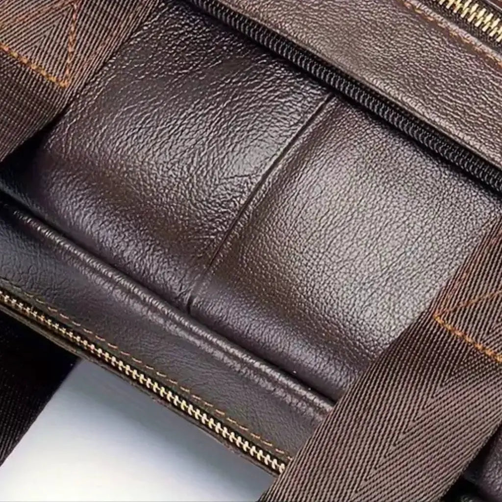 Close-up van de lederstructuur van de zakelijke laptoptas heren 15 inch bruin. De gedetailleerde opname toont de natuurlijke nerven van het hoogwaardige leer, de nauwkeurige stiksels en de zorgvuldige afwerking die deze bruine laptoptas zijn premium uitstraling geven.