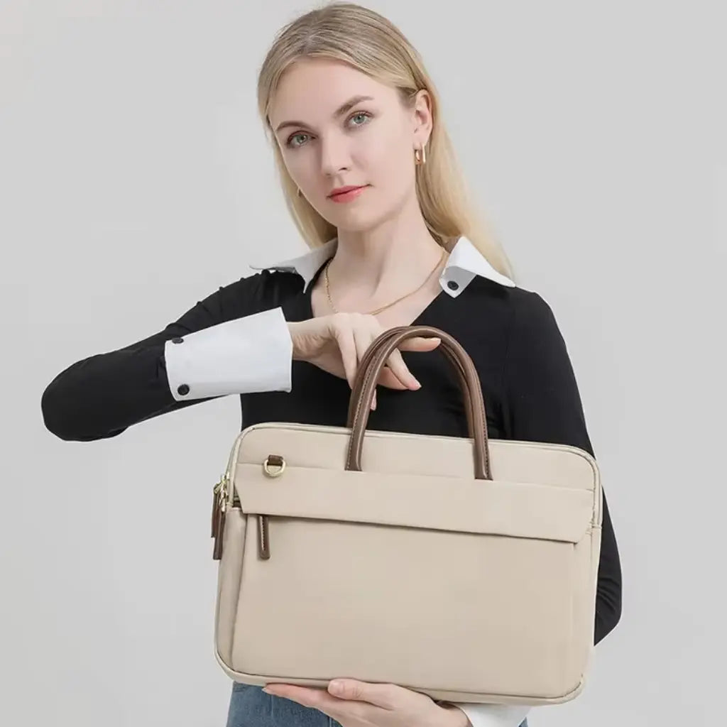 Vrouw toont de beige laptoptas voor dames in frontale positie, geschikt voor dagelijks woon-werkverkeer.