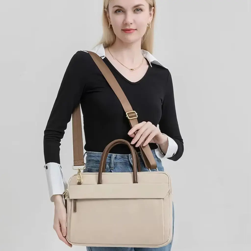 Blonde vrouw in zakelijke kleding met een beige laptoptas voor dames als stijlvol accessoire.