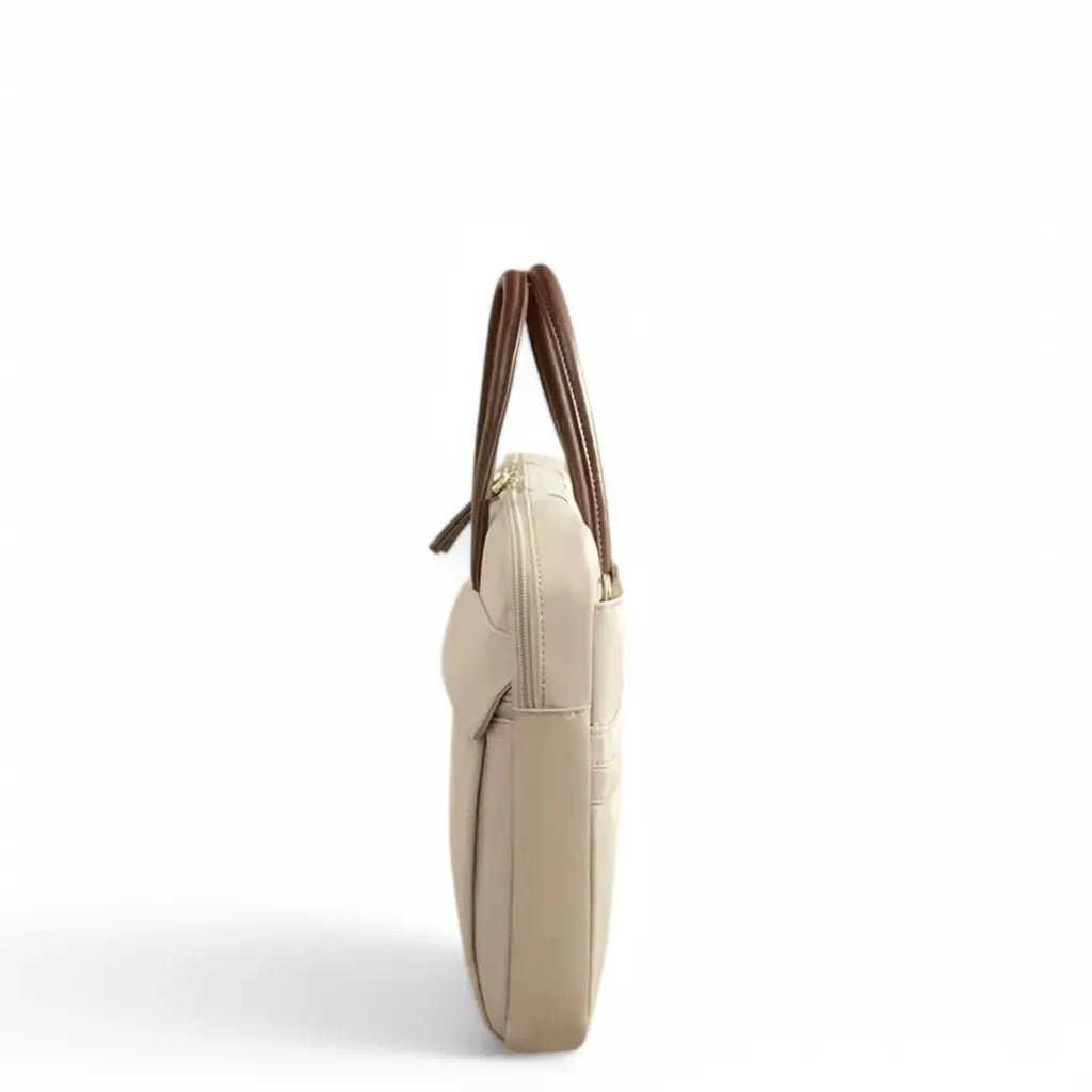 Zijaanzicht van een stijlvolle beige laptoptas voor dames met bruine handgrepen en ruime opbergruimte.