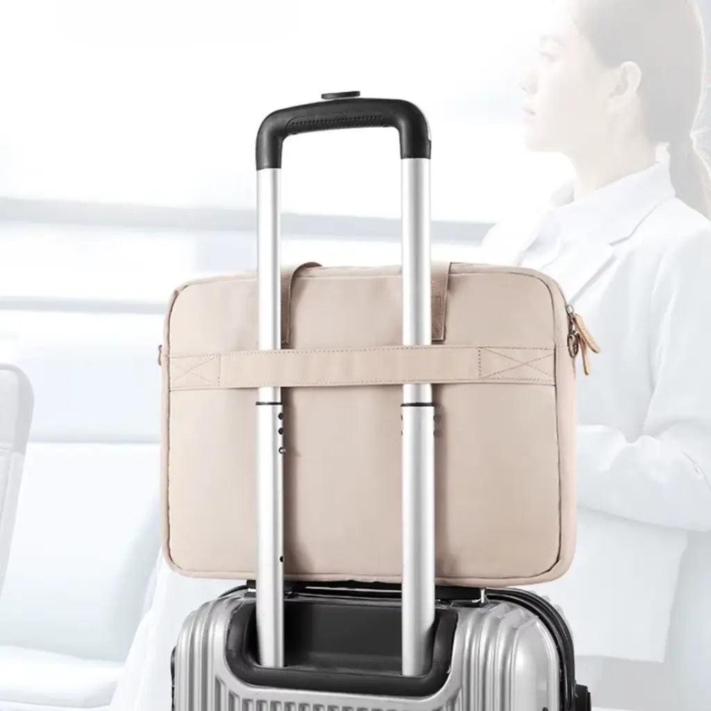 Stijlvolle laptoptas dames bevestigd aan rolkoffer voor eenvoudig reizen met speciale riem aan de achterkant.